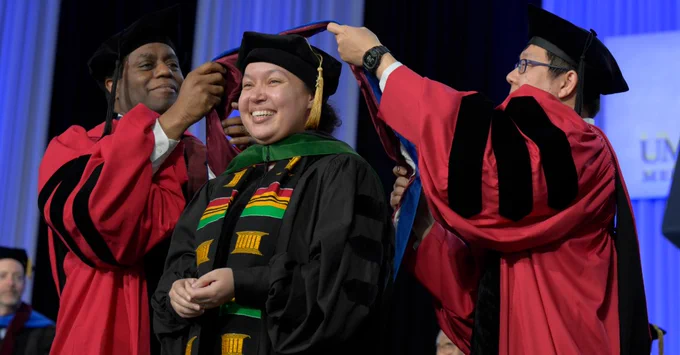 Bethany Berry, MD, PhD, wearing stoles from the Deborah Harmon-Hines, PhD, Commencement Celebration at graduation