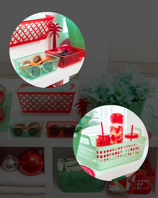 Green and red plastic baskets holding sunglasses and accessories on a white shelf with decorative elements.