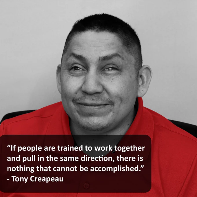Black and white photo of Tony, but with his shirt being bright red. Text reads "If people are trained to work together and pull in the same direction, there is nothing that cannot be accomplished." - Tony Creapeau