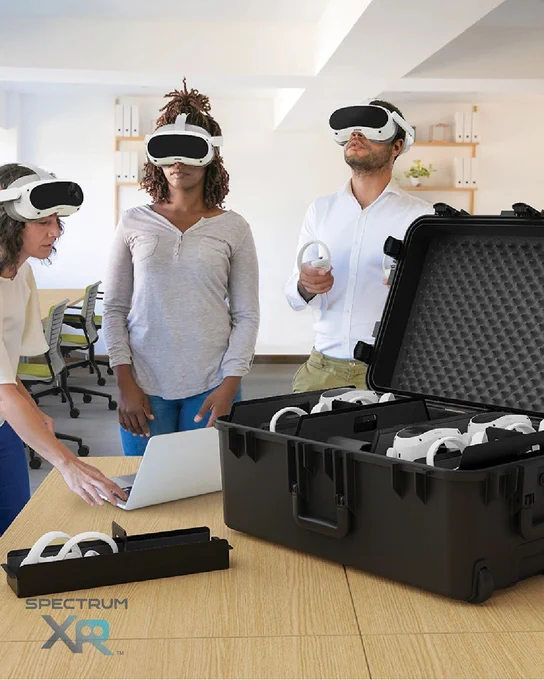 Small team training with VR headsets; open travel case on the table holding multiple devices ready for use.