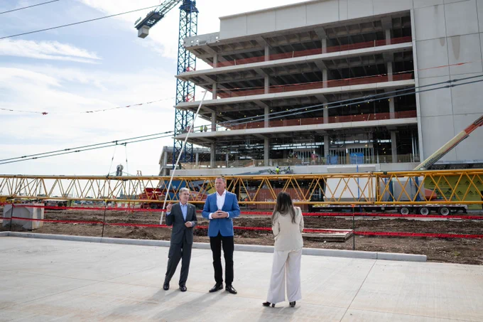 Photo of people standing in front of a construction site.