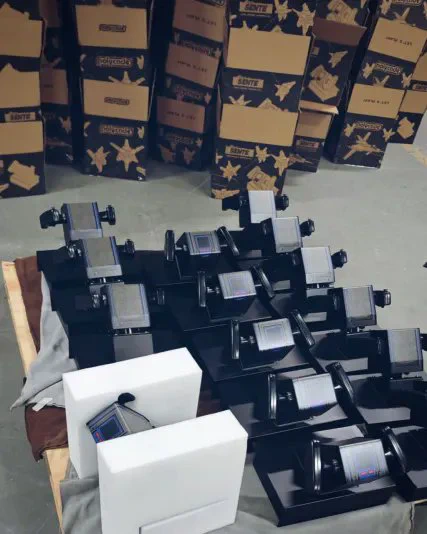 Multiple black Polycade arcade yoke controllers, surrounded by stacked cardboard boxes labeled 'SENTE'.