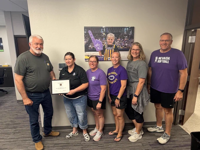 Nevada School Board Members presenting a School Board recognition salute to the Nevada Boosters for their fundraising efforts for the new video score board for the Nevada High School gymnasium.