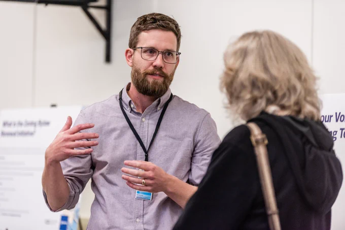 Two people talking at an engagement open house. 