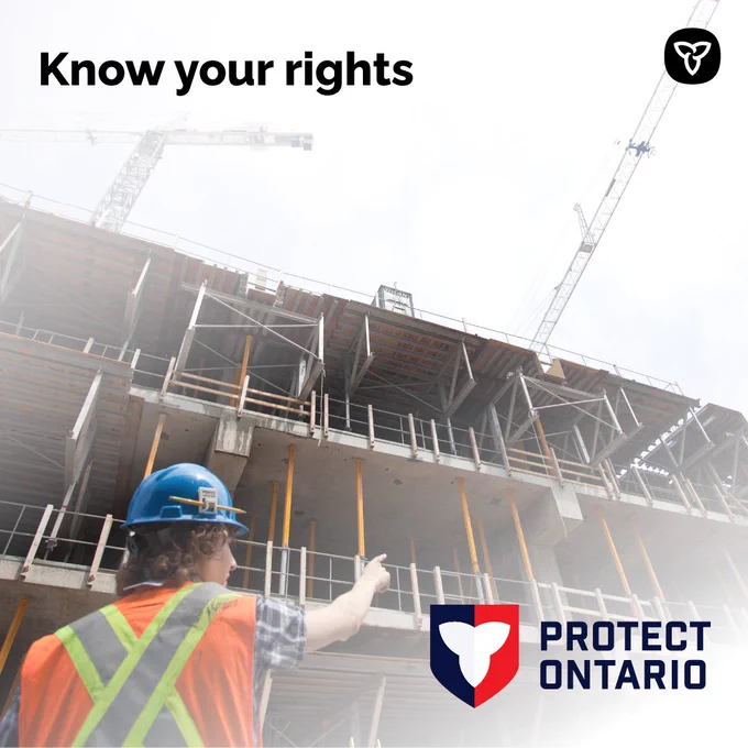 A construction worker on a job-site pointing upwards