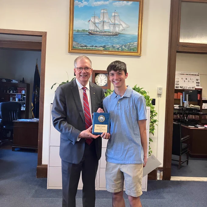 Secretary Scanlan presents a plaque and certificate to award winner Milo Cocola. 
