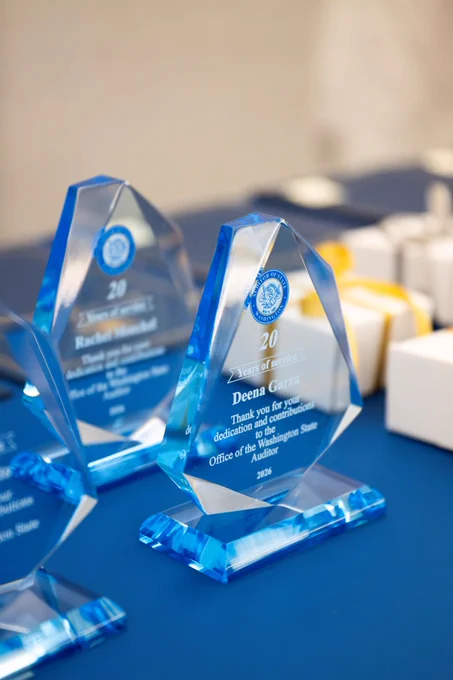 Blue crystal awards with engraved text displayed on a table at an event.