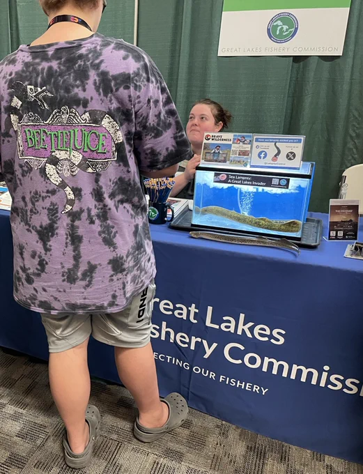 Student visiting the GLFC booth and tank of live sea lampreys at MiCareerQuest career fair. Photo credit: GLFC.