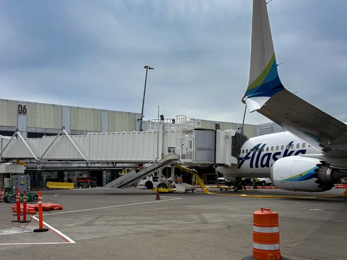 Wide view of PCL Construction’s passenger loading bridge installation at Seattle Tacoma International Airport in Seattle, Washington, showing aircraft, gate infrastructure and active airfield conditions.
