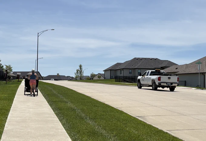 A woman pushes a stroller on Hoylake Drive as a City of Columbia truck travels by. June 3, 2026.