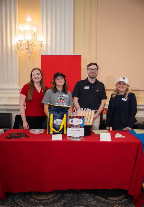 UGA Government Relations employees and interns pose for a photo in front of UGA’s Scoops for Science table.