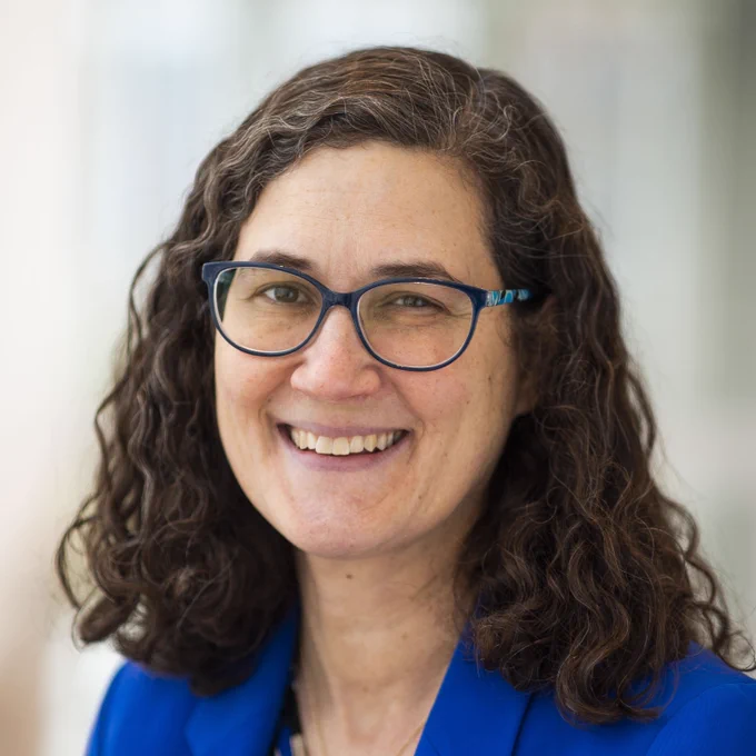 Sarah Penniston-Dorland wearing glasses and a blue blazer