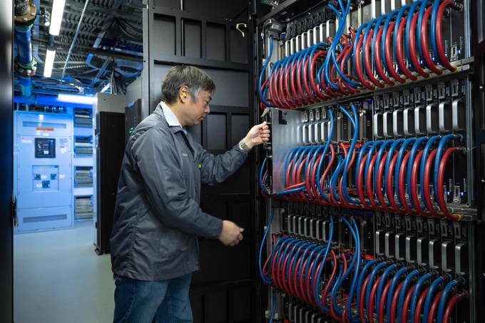Greg Chow removes a module from an Athena modular supercomputer rack in the Modular Supercomputing Facility (MSF) in R&D 99.