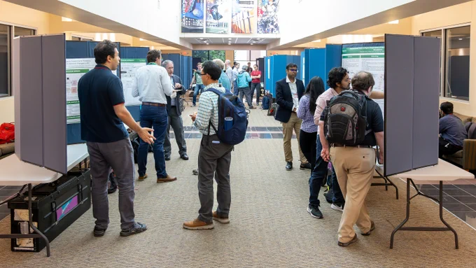 Researchers and attendees discussing scientific posters during the Oak Ridge Leadership Computing Facility User Summit poster session. 