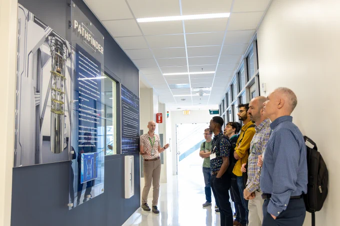 Josh Cunningham presenting to a group of Oak Ridge Leadership Computing Facility User Summit attendees during a facility tour inside Oak Ridge National Laboratory.