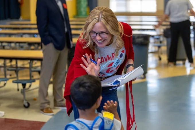 Dr. June Richland high fives a student as they walk to class from the cafeteria.