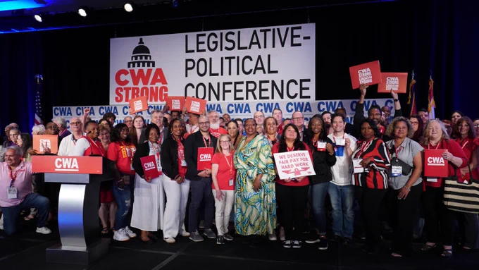A group of CWA members stand on a stage with a large sign saying "Legislative-Political Conference" behind them. 