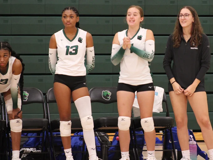 Dallas College Brookhaven volleyball players look on and cheer from the sidelines. 
