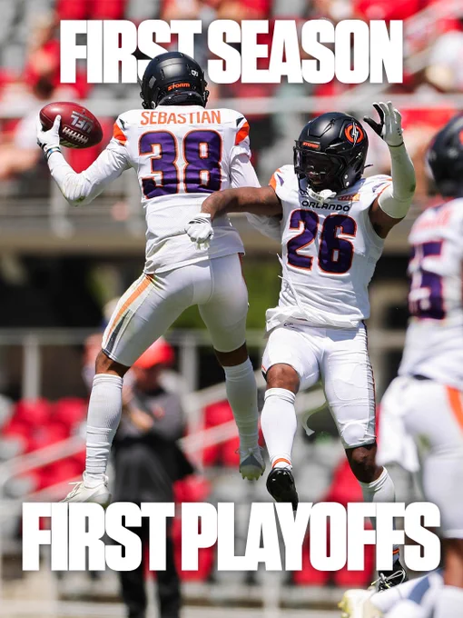 Two football players from the Orlando team celebrate by jumping in the air during a game. They are dressed in white uniforms with dark helmets, showing a sense of triumph and excitement.