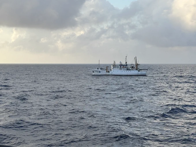 A NOAA ship passing by, right to left, in the distance.