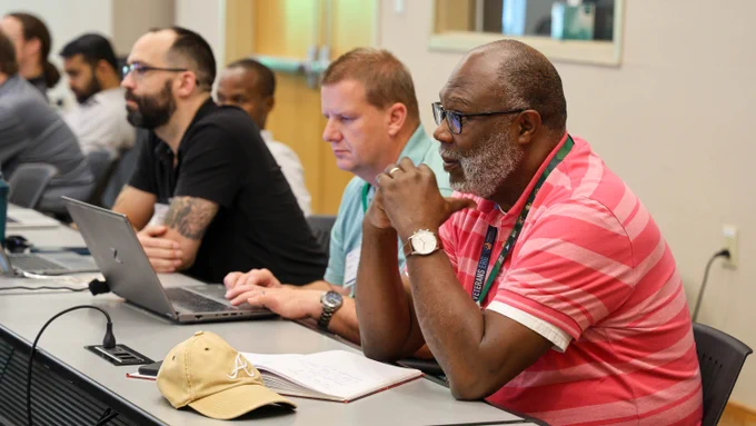 Several workshop participants listen attentively during a technical discussion at the Center for Accelerated Application Readiness workshop.