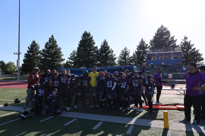 mayor with the river city grizzlies team on a football field
