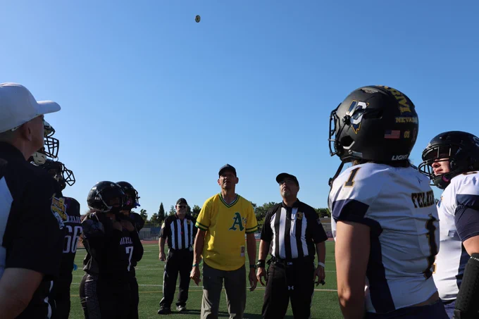mayor doing a coin toss surrounded by football coaches and players