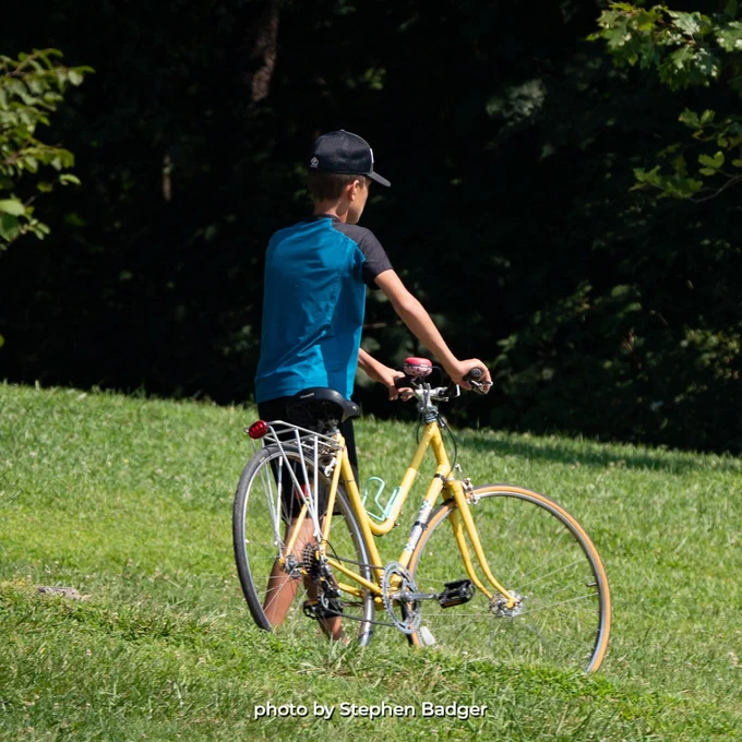 A man walking next to his bicycle.