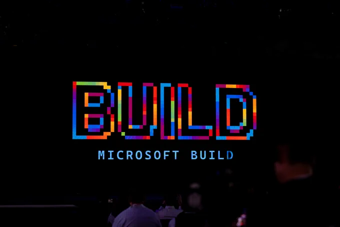 Telão exibindo logo colorido do Microsoft Build em palco escuro durante keynote.


