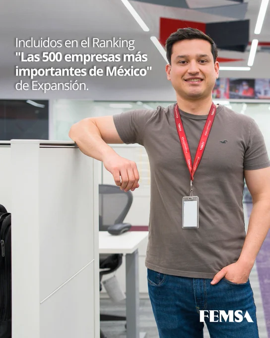 Hombre joven de pie en una oficina moderna, vistiendo camiseta gris y jeans. Lleva un gafete con cordón rojo. A su lado, un cubículo y detrás, un ambiente de trabajo iluminado. Texto sobrepuesto menciona inclusión en el ranking "Las 500 empresas más importantes de México" de Expansión. Logotipo de FEMSA en la esquina inferior derecha.