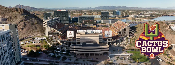 Aerial view of a large stadium hosting a football game. The stands are filled with spectators. The stadium is surrounded by a cityscape and mountains. A logo in the foreground shows the Cactus Bowl.