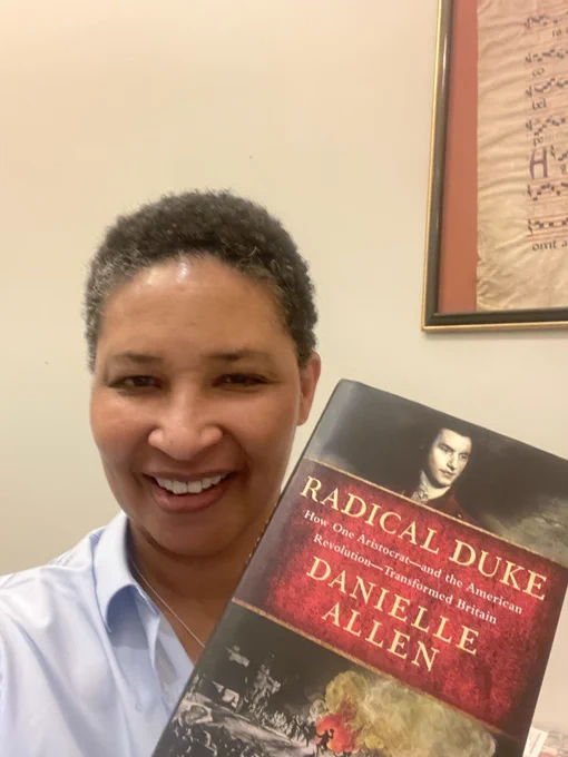 Danielle holding up a copy of her new book, Radical Duke.