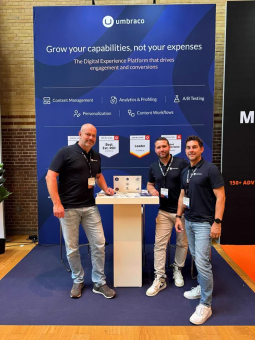 3 men standing in front of backdrop at conference
