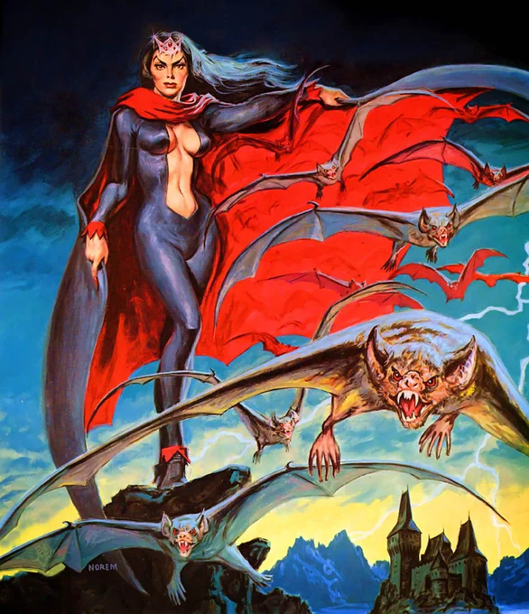 A woman in a tight fitting outfit and cape, stands on rocks next to  a castle as bats fly past her.
