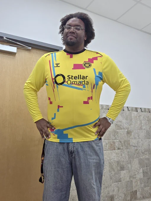 A picture of me with my hands on my hips. I am wearing a long sleeve Hearts FC goalkeeper jersey.