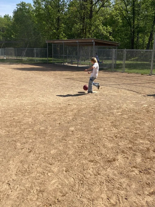 6th grade student kicking the kick ball at home plate