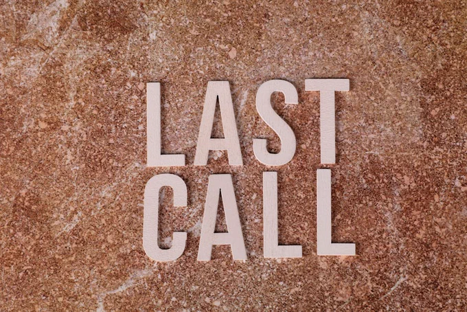 A top view of wooden letters spelling 'Last Call' on a textured brown surface.