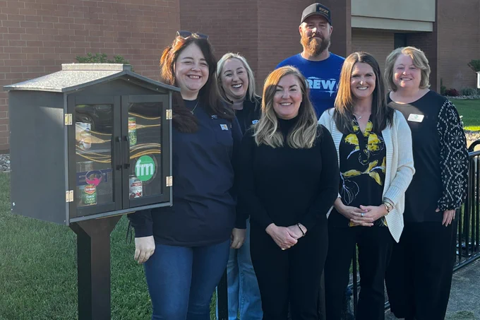 A group of people standing beside the Community Blessing Box at McNinch Primary School. 