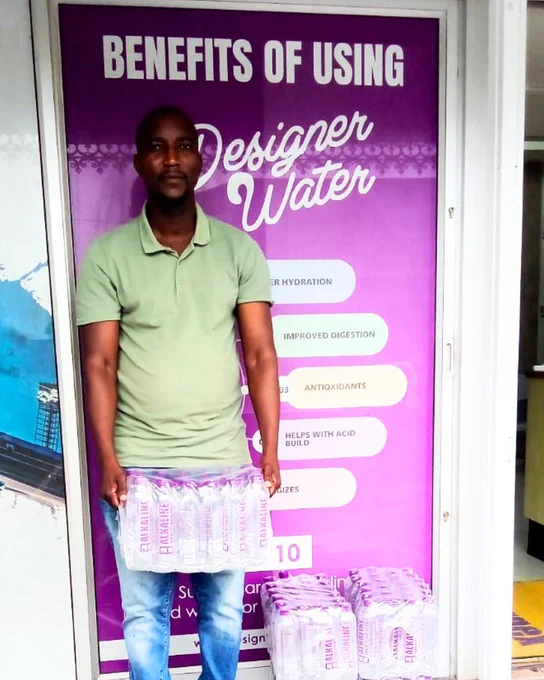 Jabulani standing with a case of Designer Water pH10 outside the Master Distributor's warehouse in Morningside, Durban.