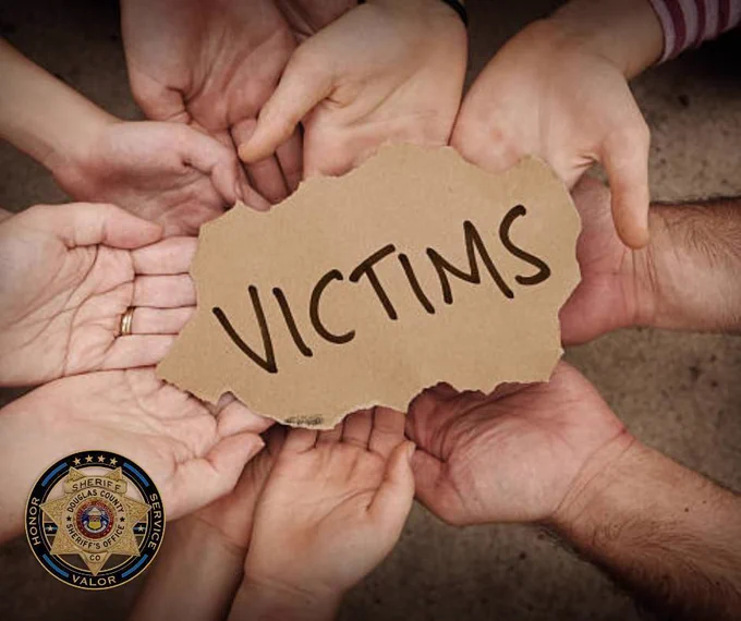 Hands holding victim sign, with DCSO logo Honor Service Valor