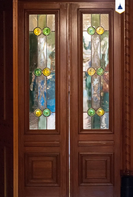A pair of pine doors with stained glass windows. 