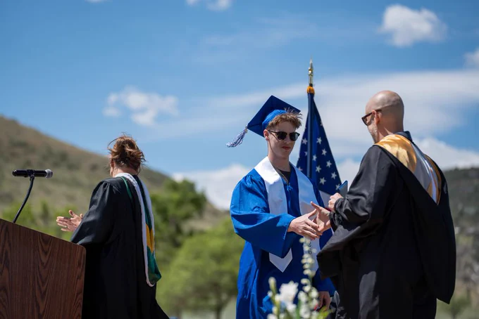 A Lyons Middle Senior High School senior shakes hands with the principal after receiving his diploma.