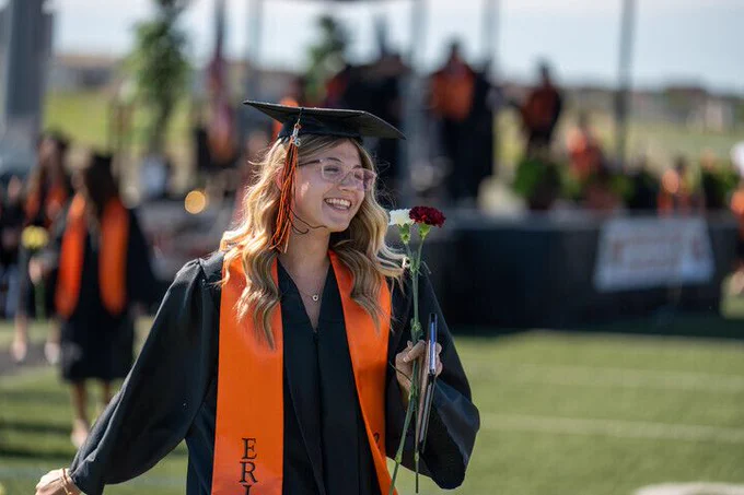 An Erie High School student smiles as she walks off stage after receiving her diploma.
