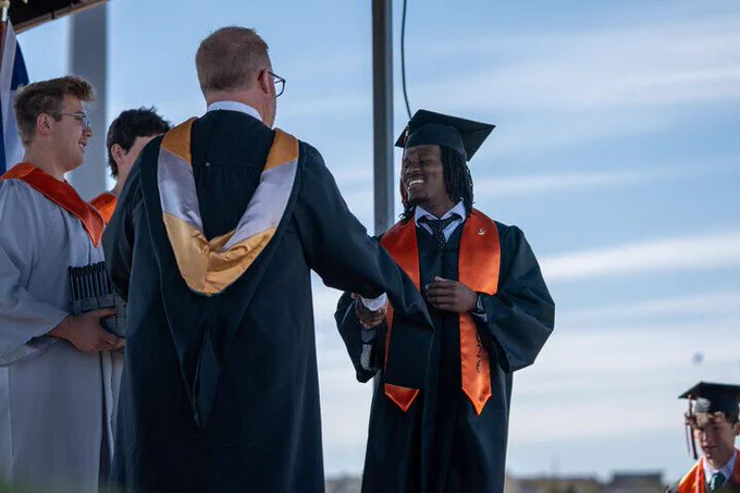 An Erie High School student shakes his principal's hand as he receives his diploma.
