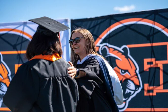 A teacher congratulates a student on their graduation from Erie High School.