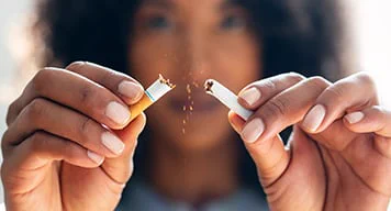 Woman breaking apart cigarette 