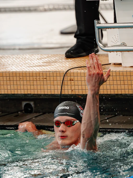 Image of Quintin McCarty celebrating after his race in the pool, with hand up.