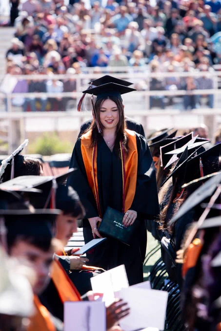 A MHS graduate returns to their seat after receiving their diploma.