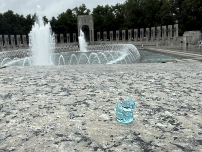 A very small blue transparent duck figurine