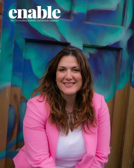 An image of Isabelle Pearcey. She is smiling, has long auburn hair, and Is wearing a pink suit jacket and white top.